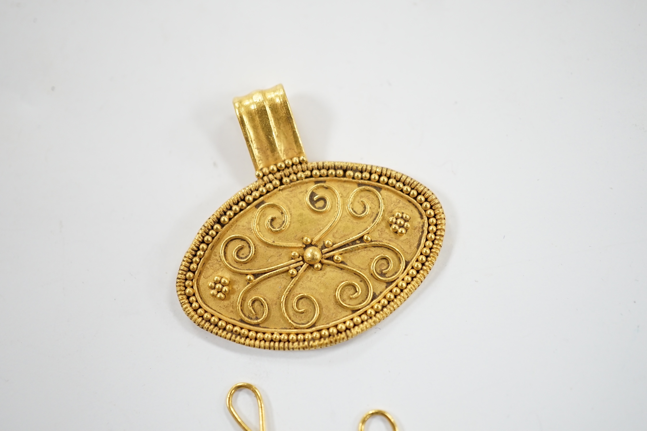 A pair of Middle Eastern two colour sapphire? cluster set drop earrings, the fittings stamped 916, together with a Middle Eastern yellow metal oval pendant, 26mm, with wirework decoration, gross weight 6.7 grams.